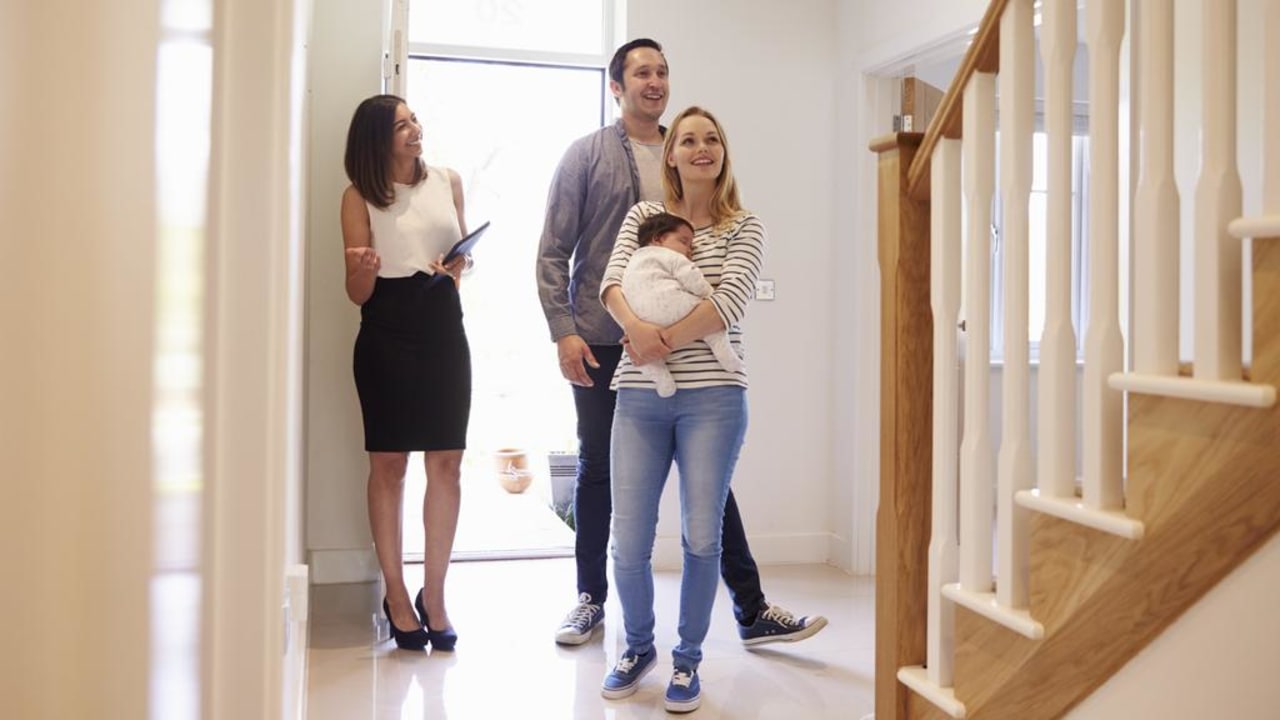 Realtor Showing Young Family Around Property For Sale